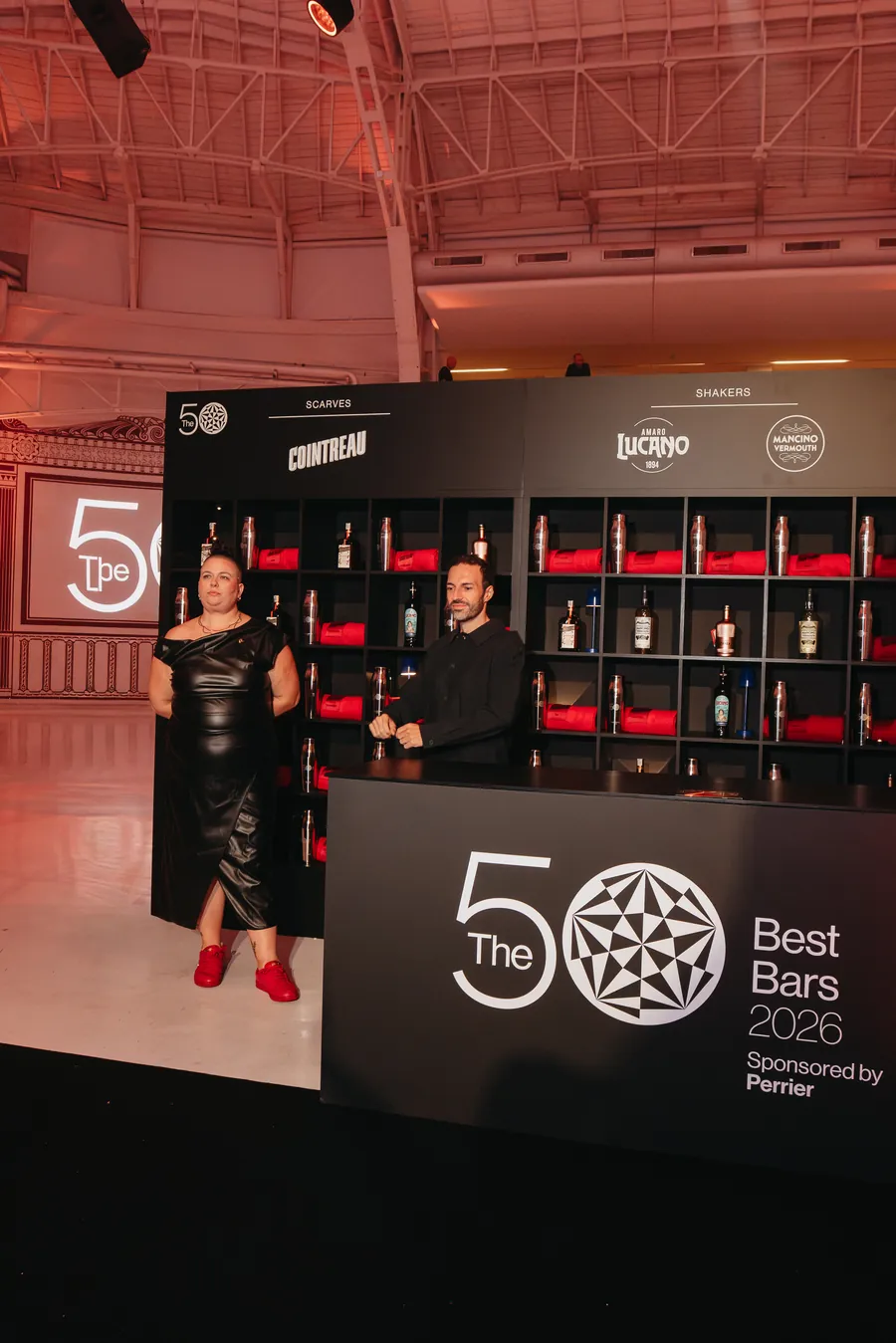 Cointreau at The 50 Best Bars 2026: shelf wall with red scarves and bottles at the stand in Milan