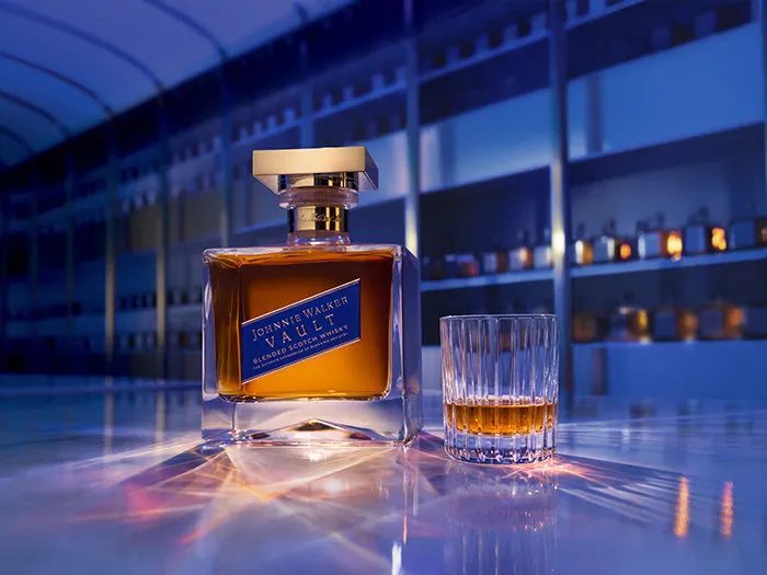 Johnnie Walker Vault blended Scotch whisky: bottle with a golden stopper next to a filled tumbler