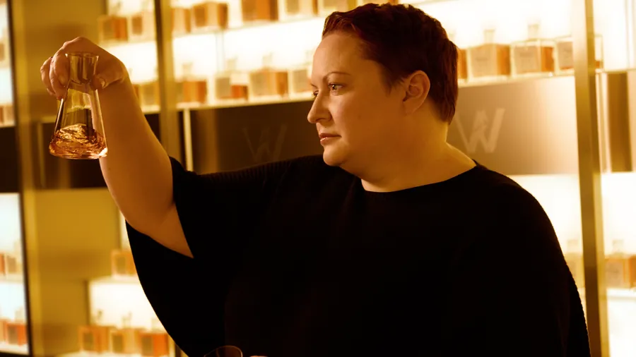 Johnnie Walker Vault: Master Blender Dr. Emma Walker examines a whisky sample in a glass in front of illuminated shelves