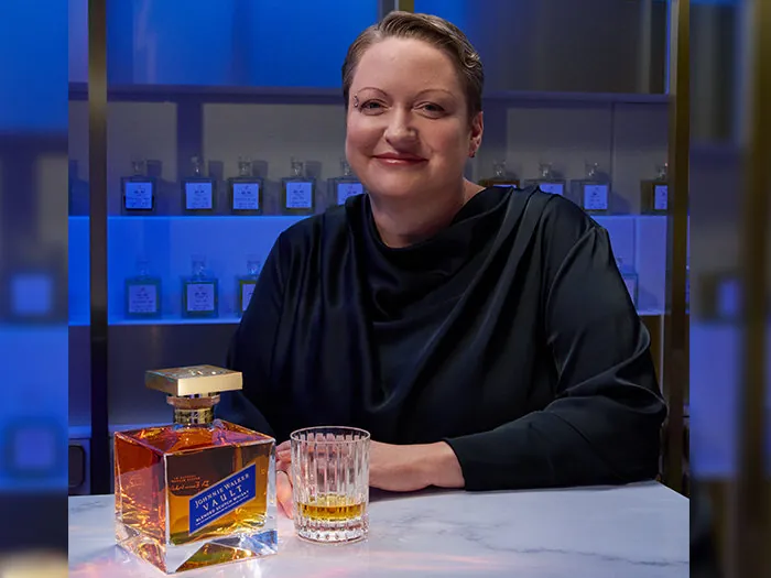 Dr. Emma Walker, Johnnie Walker Master Blender, with a bottle of Johnnie Walker Vault at a counter